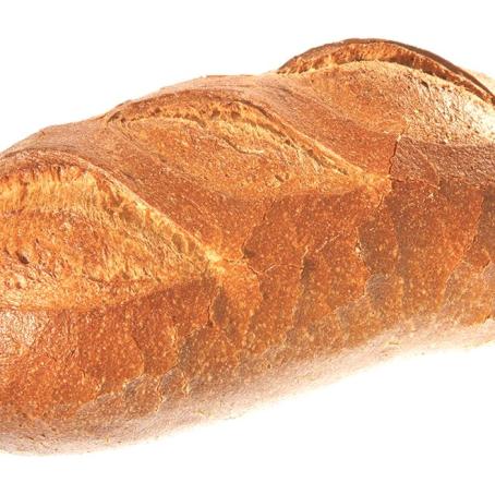 Ein rustikaler, goldbrauner Brotlaib, der auf einem weißen Hintergrund präsentiert wird.