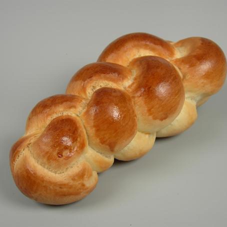 Ein gebackenes, geflochteneres Brotgebäck mit goldbrauner Kruste.